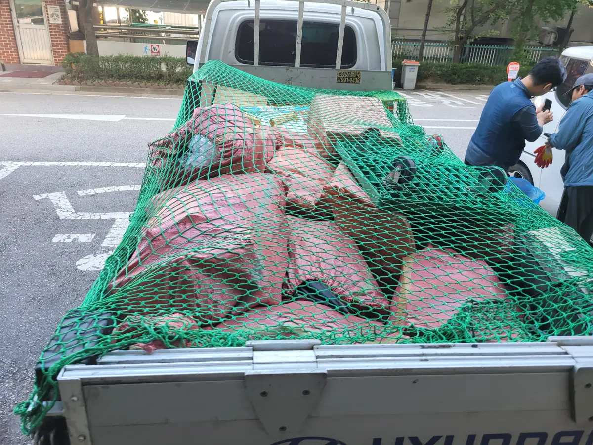 집정리 작업 차량 적재함에 물품을 싣고 망으로 고정한 상담 안내 이미지