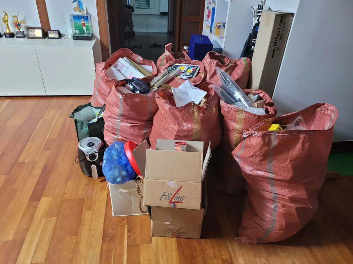 이사를 앞두고 거실에 포장된 자루와 상자, 생활물품이 모여 있는 집정리 작업 전 현장